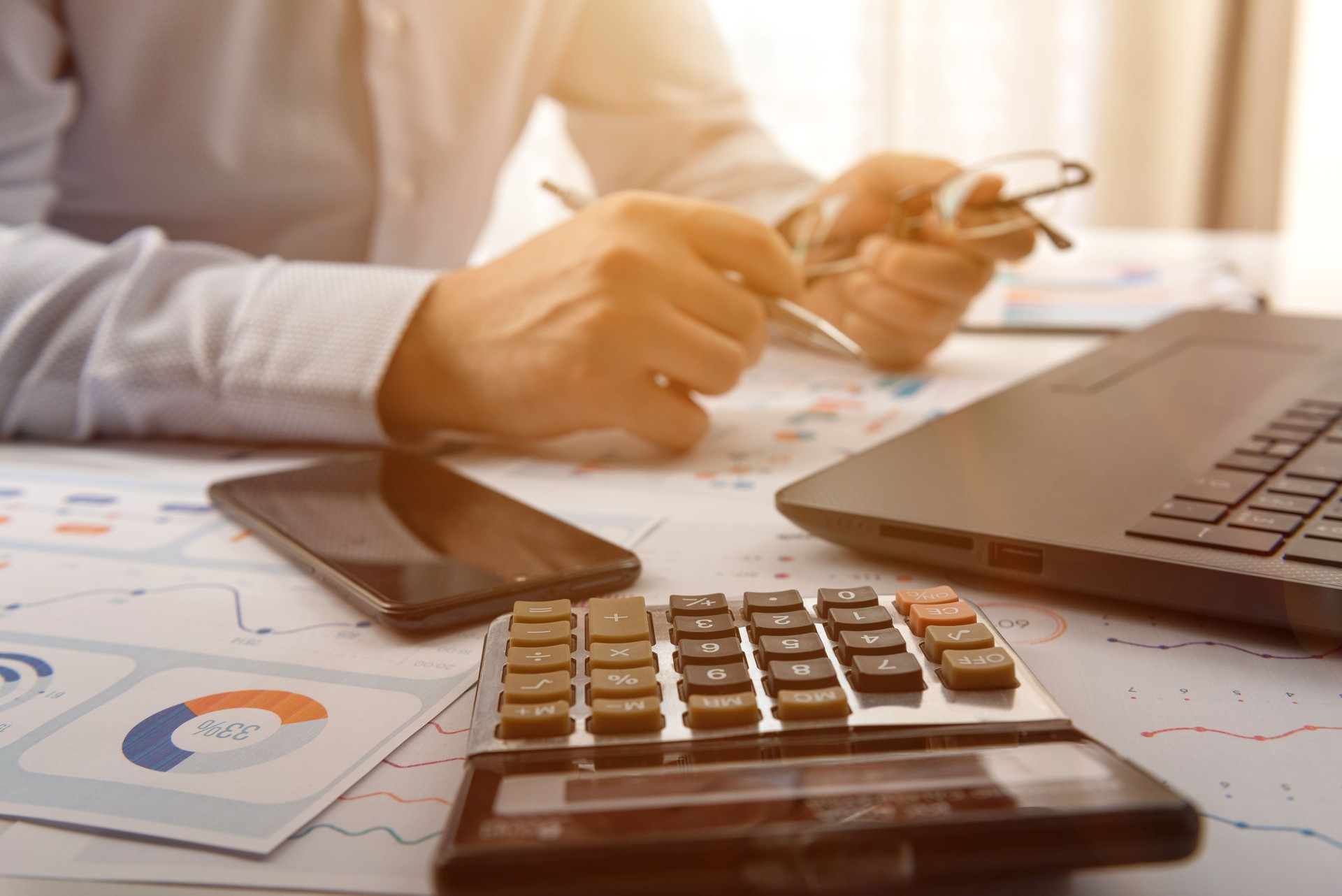 Businessman is calculating by looking at financial graphs. Business accounting concept.