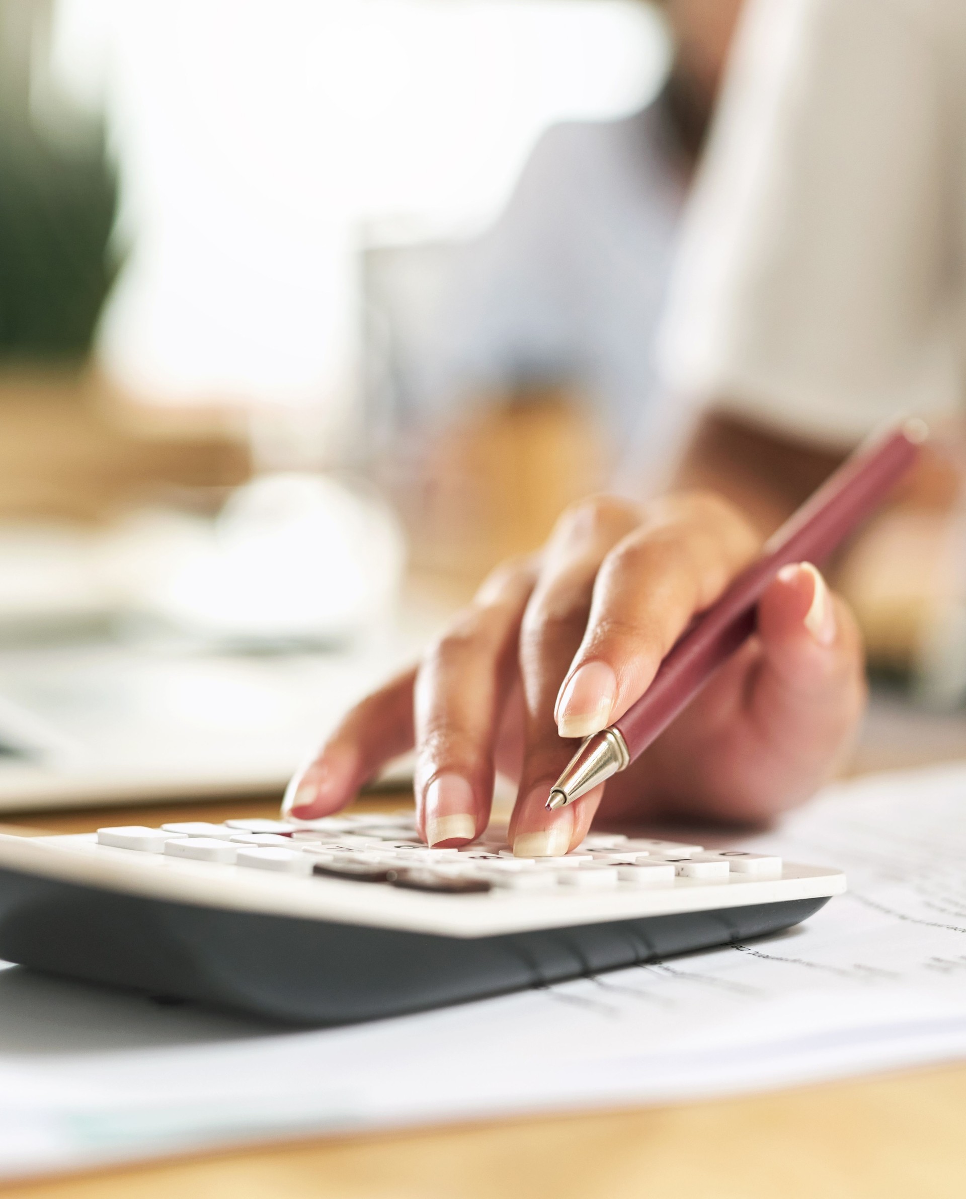 Shot of a businesswoman using a calculator to budget her finances
